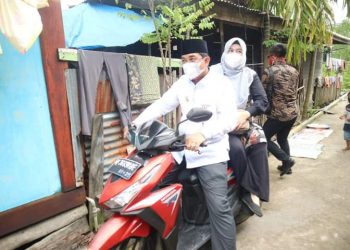 Kendarai Motor, Bupati Tanjabbar Bagikan Sembako ke Rumah Warga